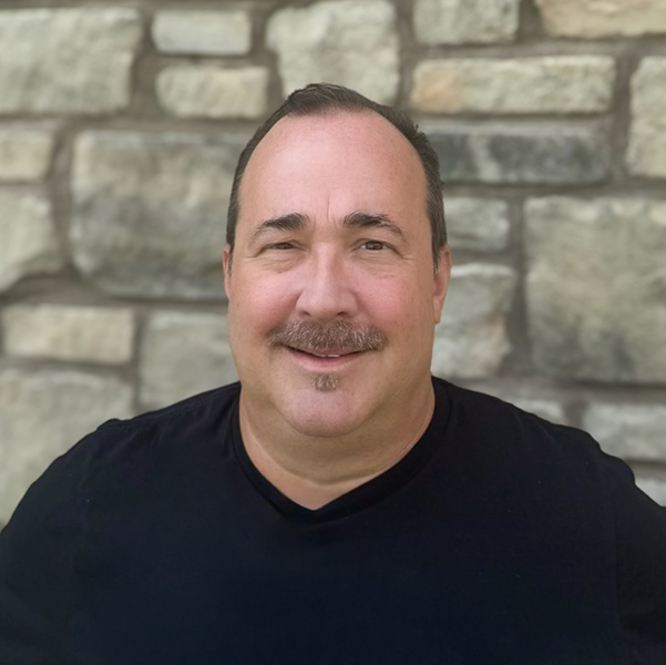 - [ ] Michael Seelbach, the Wellness Director at The Barrymore Senior Living, wearing a black shirt and smiling in front of a stone wall background.