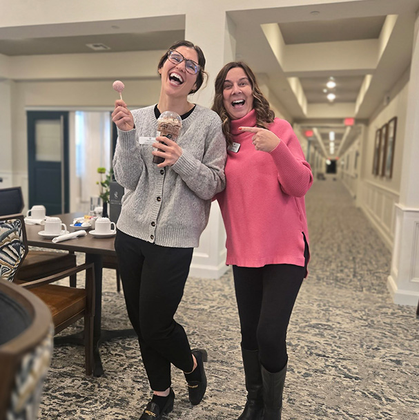 Two women on the Barrymore team smile and laugh in an elegantly decorated common space.