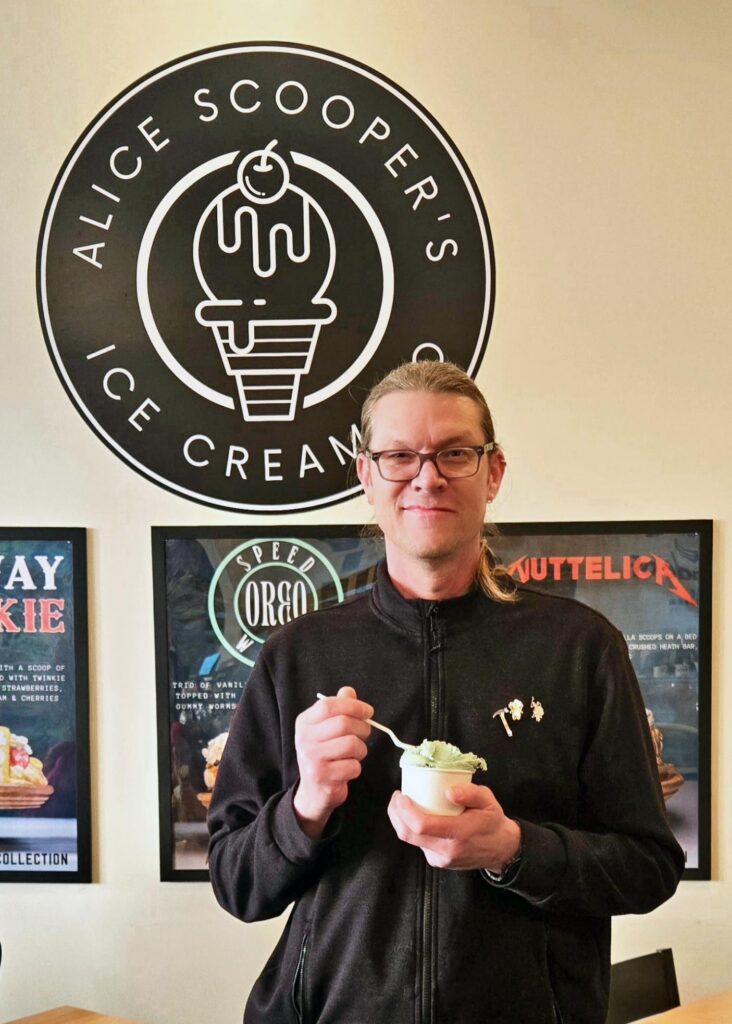 A man smiles with a sweet treat at Alice Scooper's Ice Cream in Kansas City.