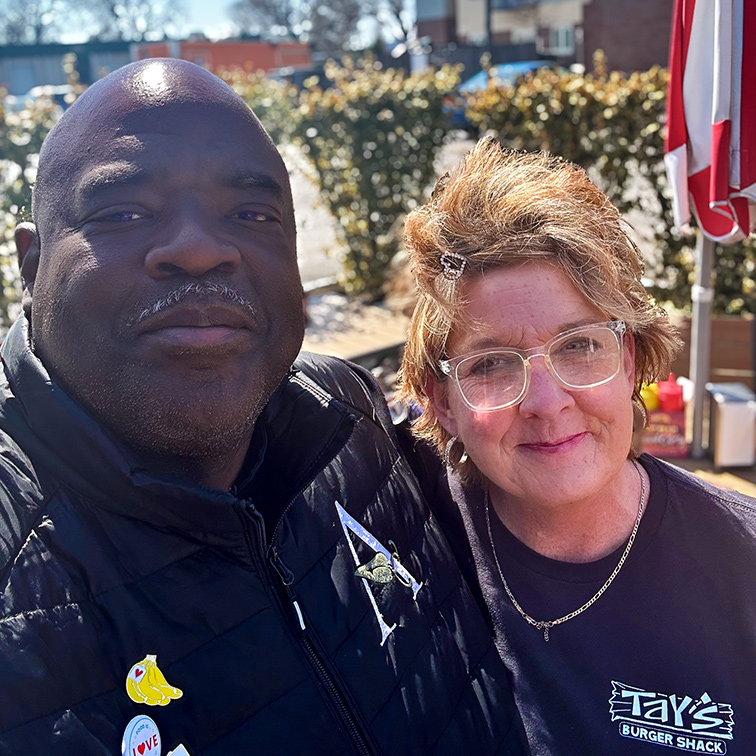 A man on the Arrow team smiles beside a woman from a local business.