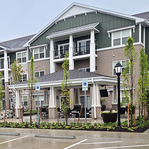 The exterior of The Barrymore Senior Living, showcasing freshly planted flower beds.
